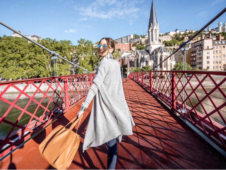 Une femme sur un pont traversant la Saône direction le Vieux Lyon
